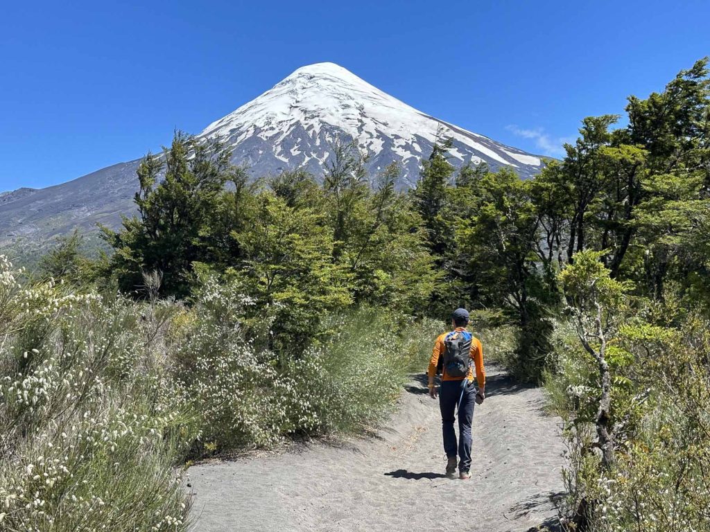 Wanderer vor schneebedecktem Vulkan Osorno, während der Wanderung im Vicente Pérez Rosales Nationalpark, Chile