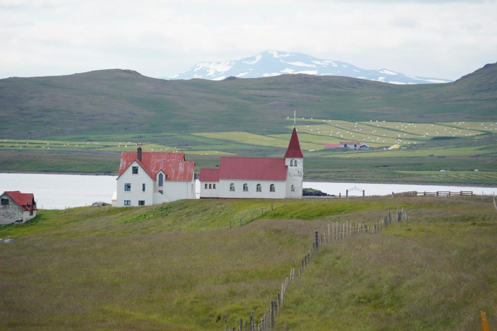 Kirche vor schneebedeckten Bergen - Rundreise Island