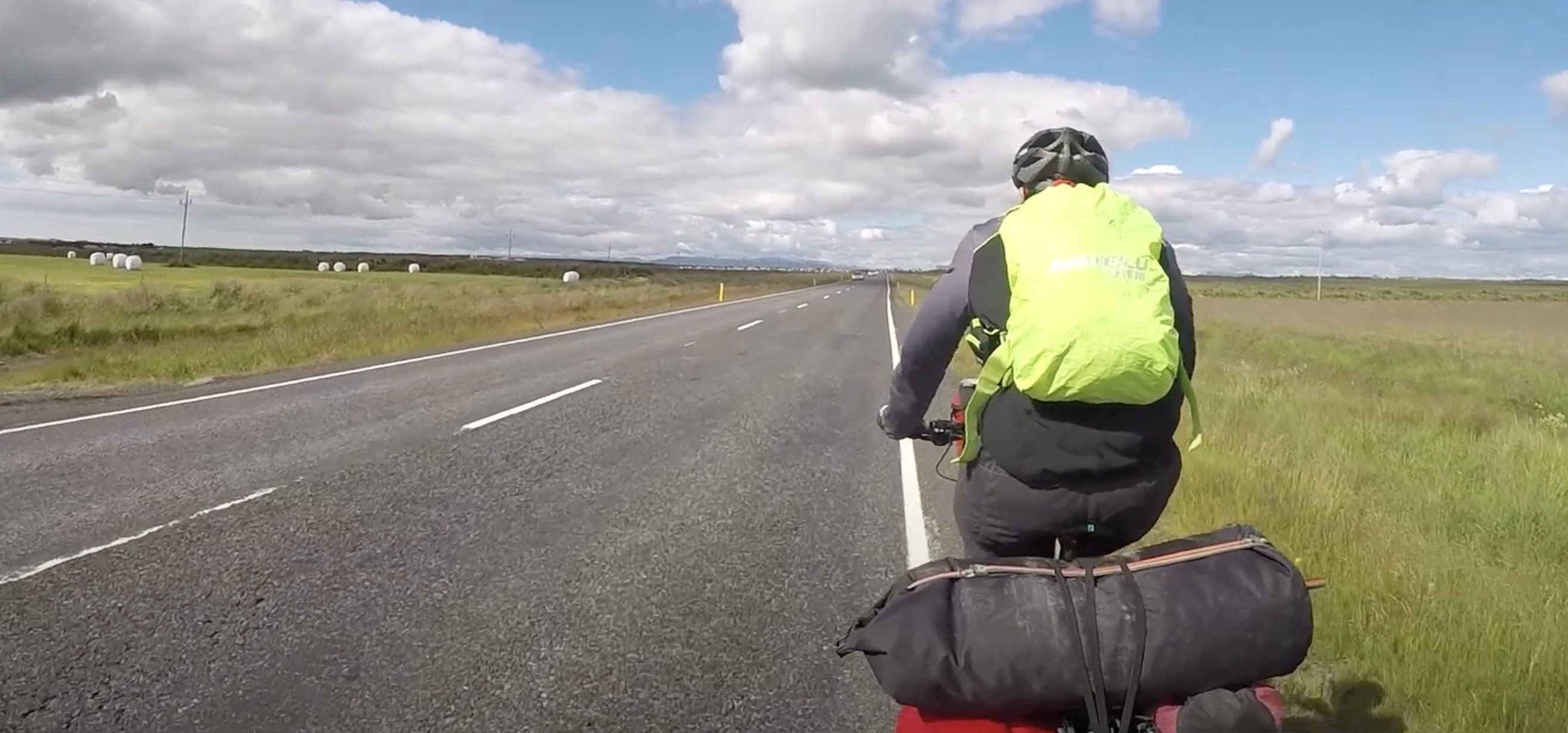 Fahrradfahrer entlang einer Asphaltstraße - Bikepacking in Island