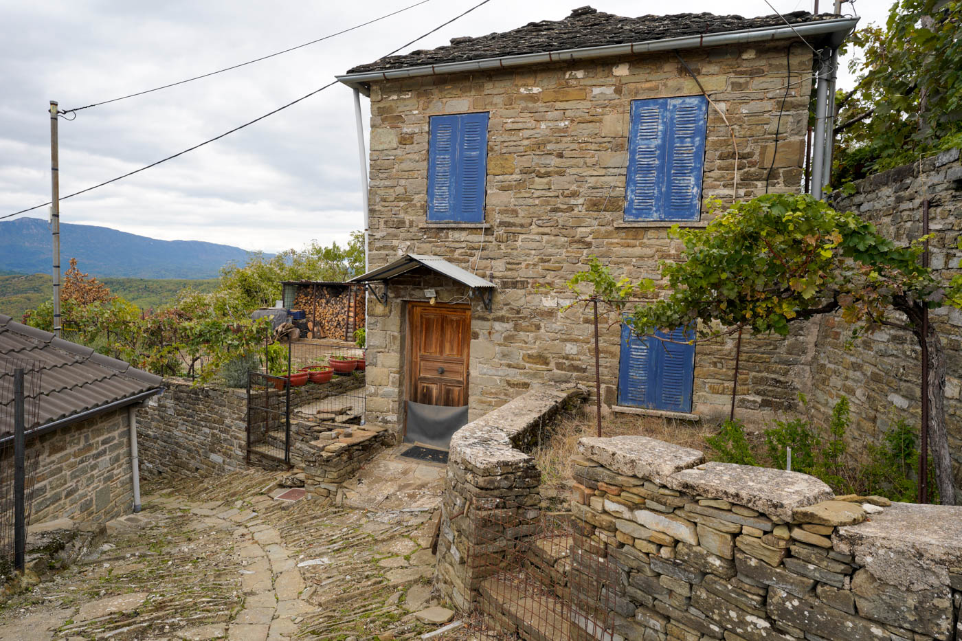 Steinhaus mit blauen Fensterläden in Fragkades